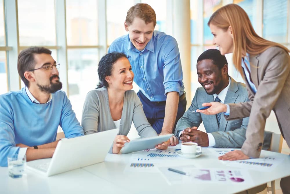 Une équipe RH qui révise des documents autour d’un portable