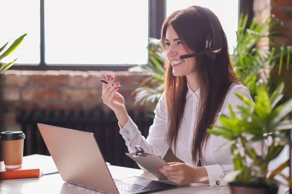 Une représentante avec un casque, au travail sur un portable